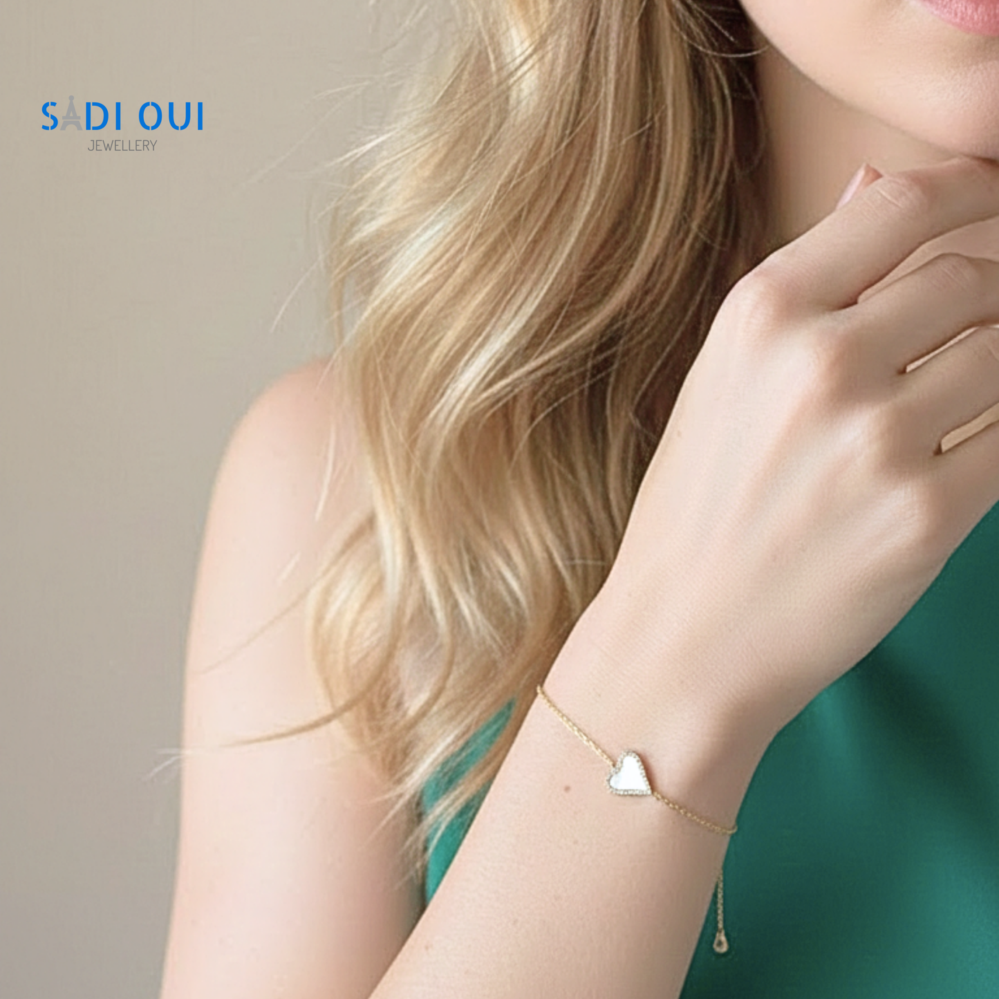 Pulseira Sentir SADI OUI em aço inoxidável dourado com coração branco em fundo claro em modelo